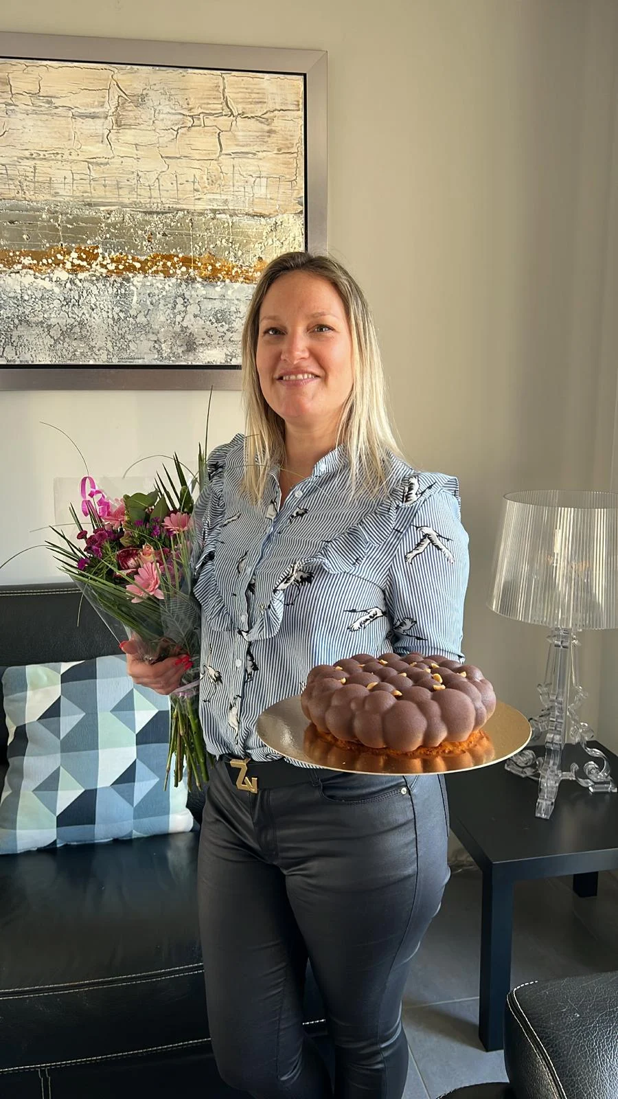 Alexia Moreno souriante, un bouquet à la main, près d’un gâteau