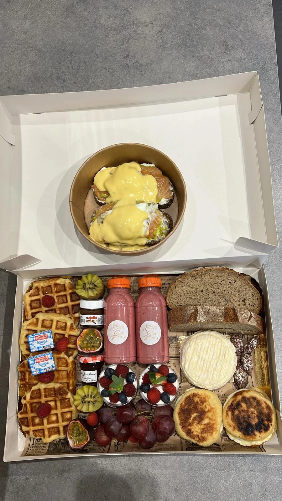 Box brunch composée de gaufres, pains, fruits, fromages et smoothies