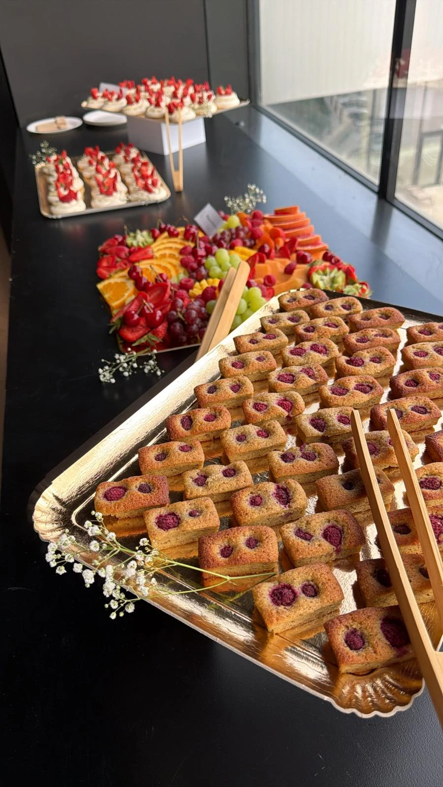 Buffet de financiers, fruits et desserts dressé pour une réception