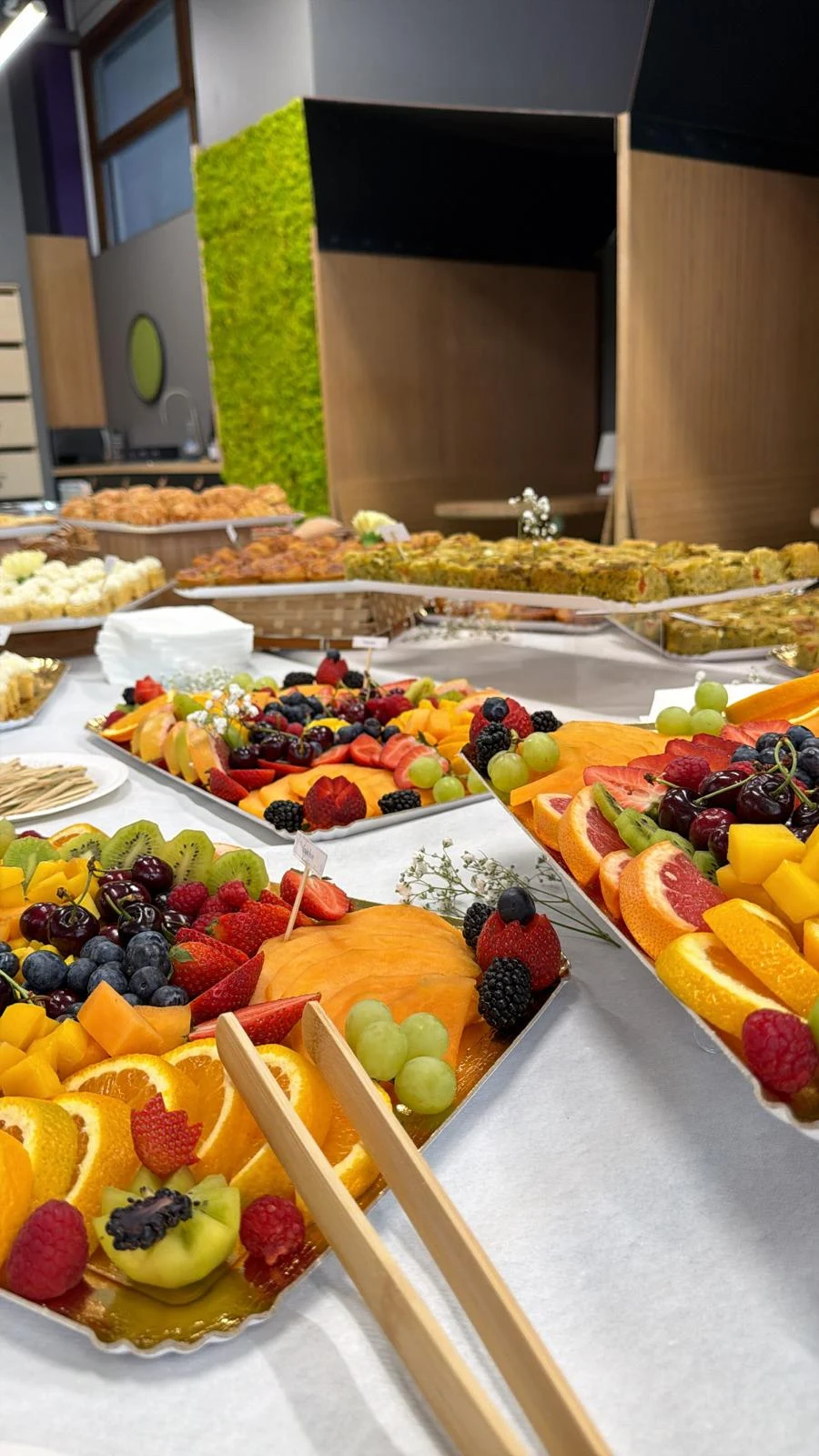 Buffet de fruits frais découpés et présentés sur plusieurs plateaux