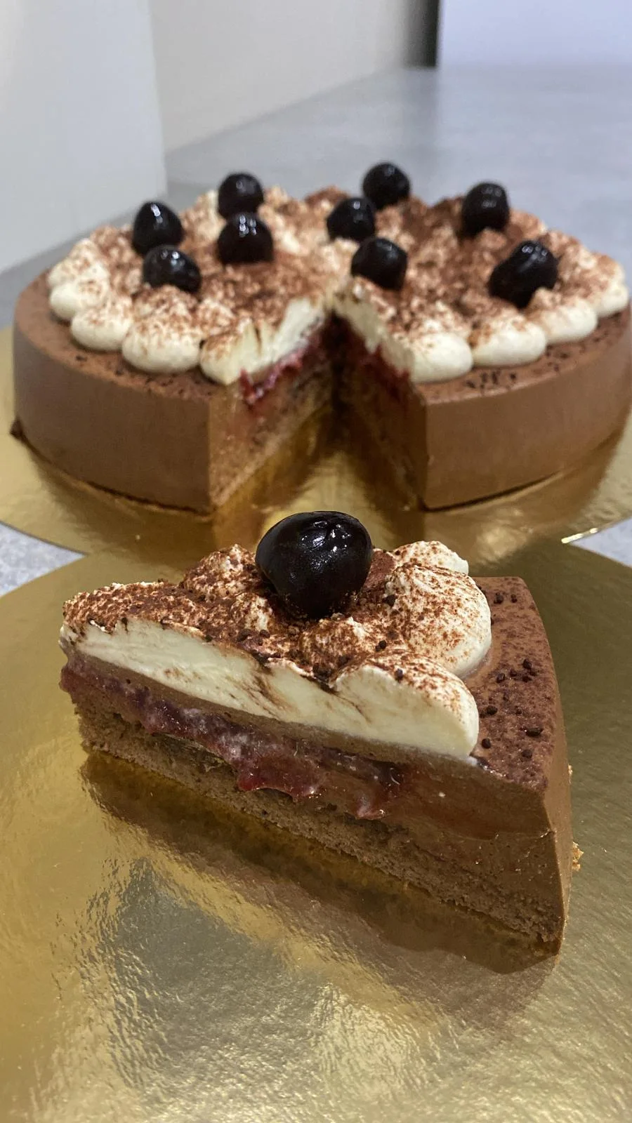 Part d’entremet Forêt-Noire présentée devant le gâteau
