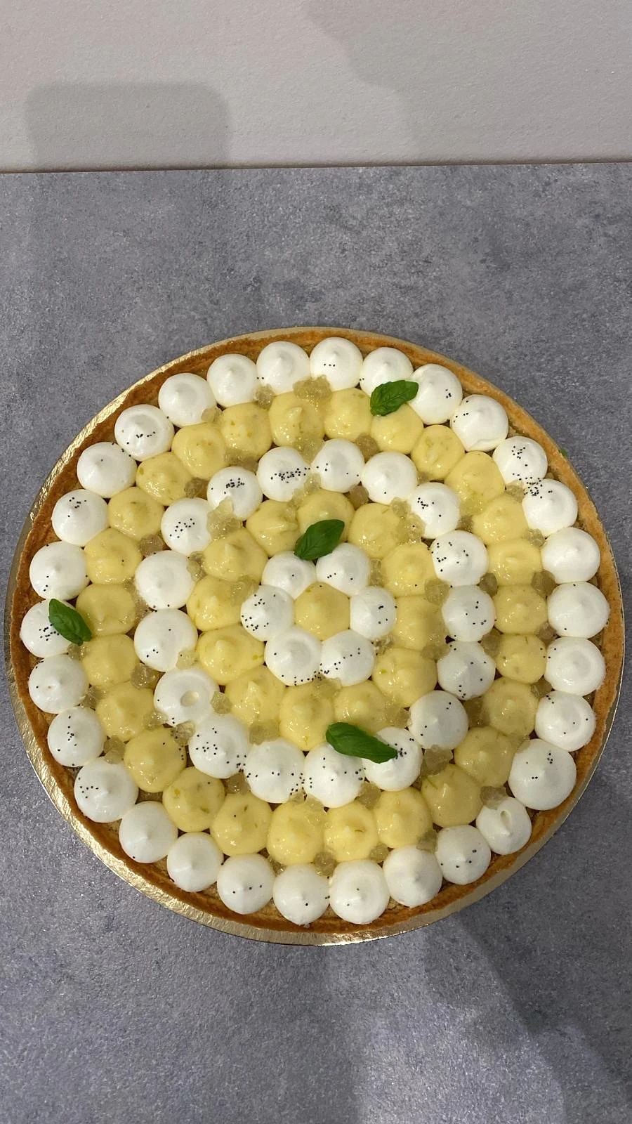 Tarte au citron décorée de crème et de petites feuilles