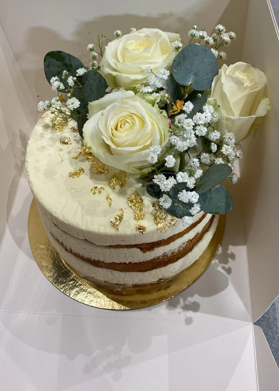 Wedding cake blanc décoré de roses, de gypsophile, d’eucalyptus et de feuille d’or